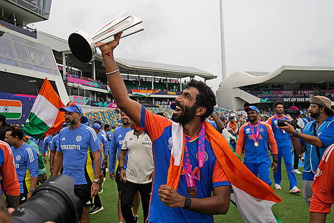 Jasprit Bumrah celebrates with the winners' trophy